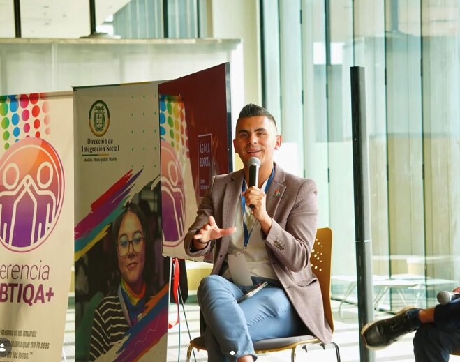 Johan Angel speaking with a microphone during a panel discussion
