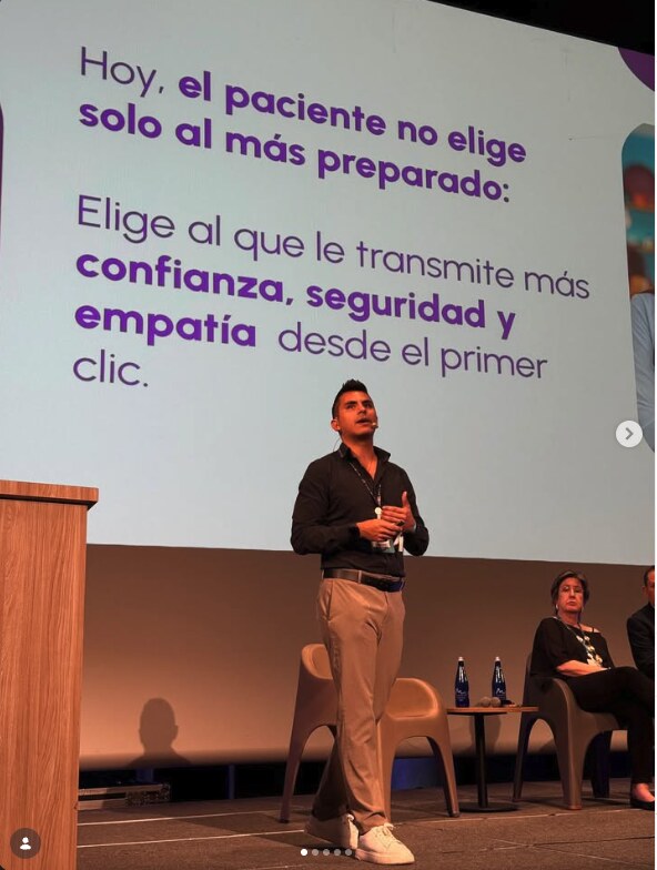 Johan Angel giving a talk on stage in front of a presentation screen